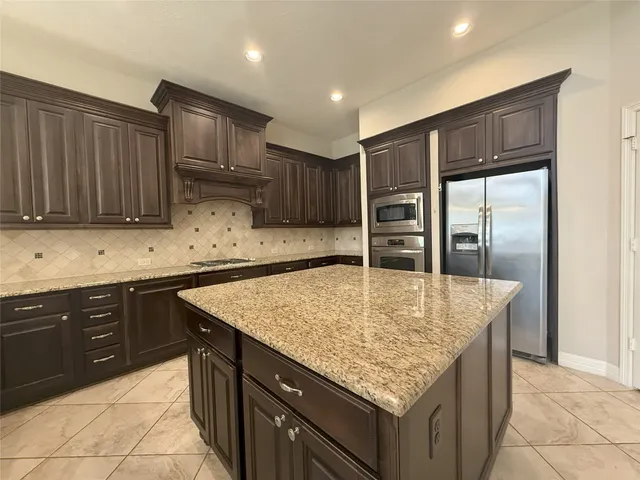 a kitchen with granite countertop cabinets and steel appliances