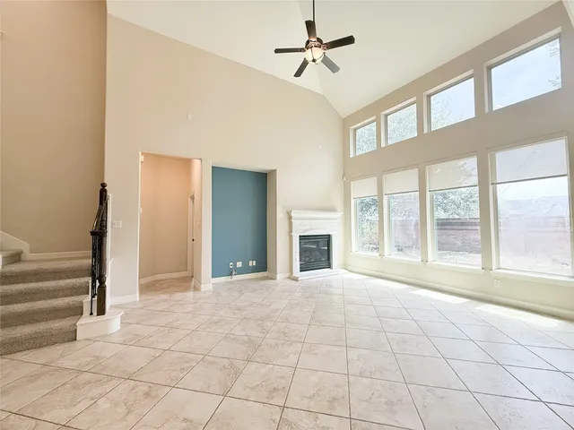 a view of an empty room with a fireplace and a window