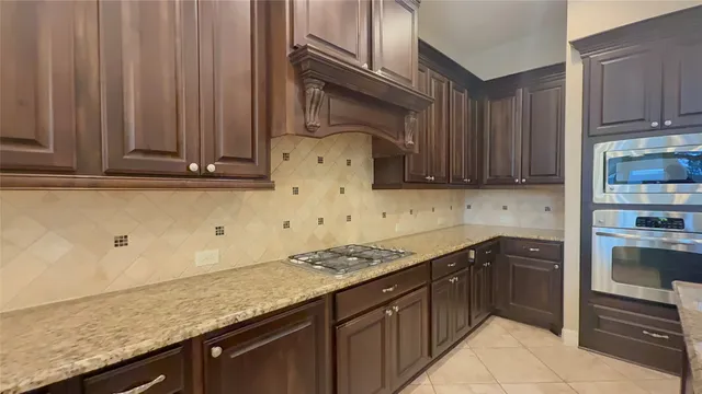 a kitchen with stainless steel appliances granite countertop a refrigerator and a stove top oven