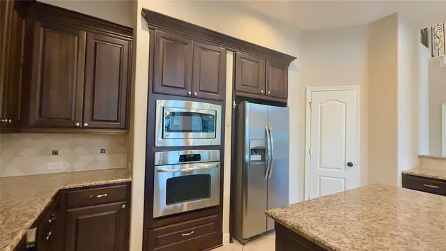 a large kitchen with granite countertop a sink and a stove