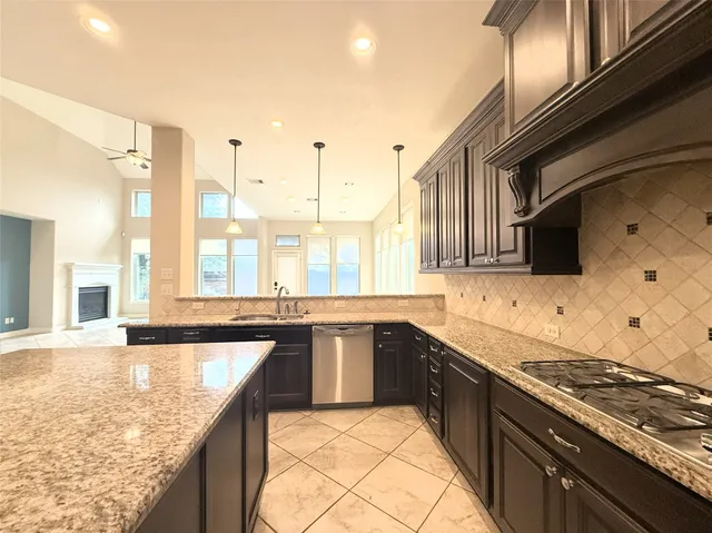 a kitchen with stainless steel appliances granite countertop a sink and a refrigerator