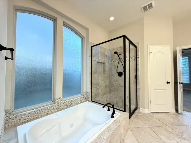 a bathroom with a bathtub and a shower