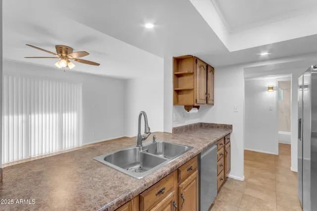a kitchen with stainless steel appliances granite countertop a sink and a refrigerator