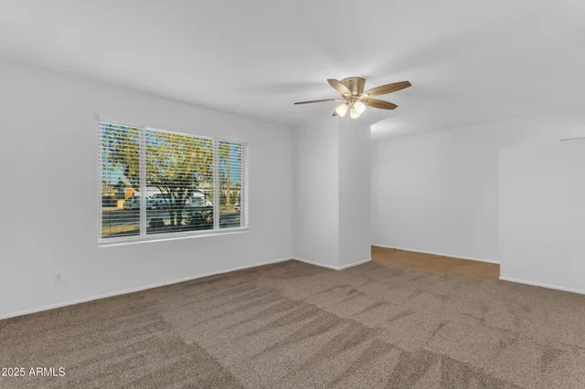 a view of a big room with windows and ceiling fan