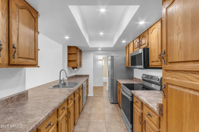 a kitchen with stainless steel appliances granite countertop a sink a stove and a refrigerator