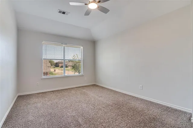 an empty room with a window and a ceiling fan