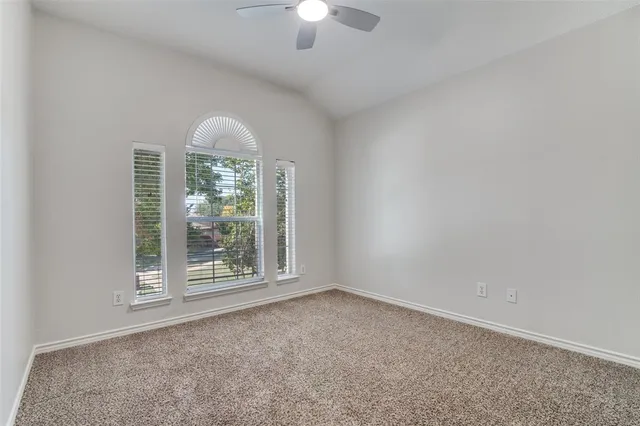 an empty room with a fireplace and large windows