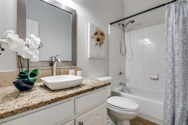 a bathroom with a granite countertop sink a toilet and a mirror