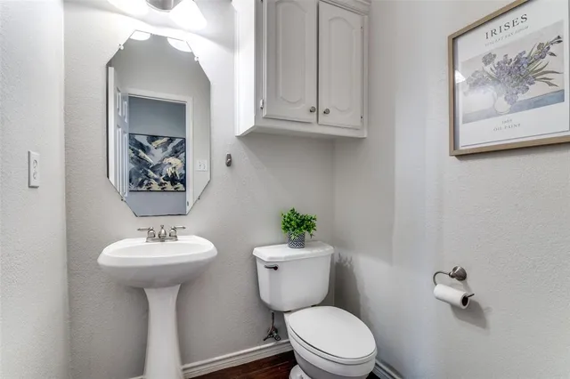 a bathroom with a toilet a sink and mirror