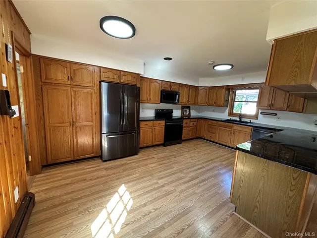 a kitchen with wooden floors and wooden cabinets