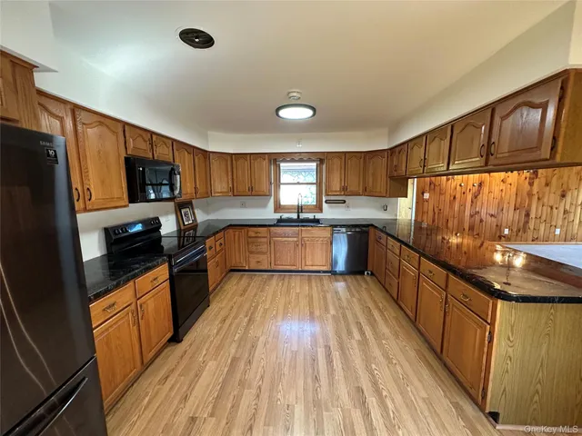 a kitchen with granite countertop wooden floors a stove and a sink