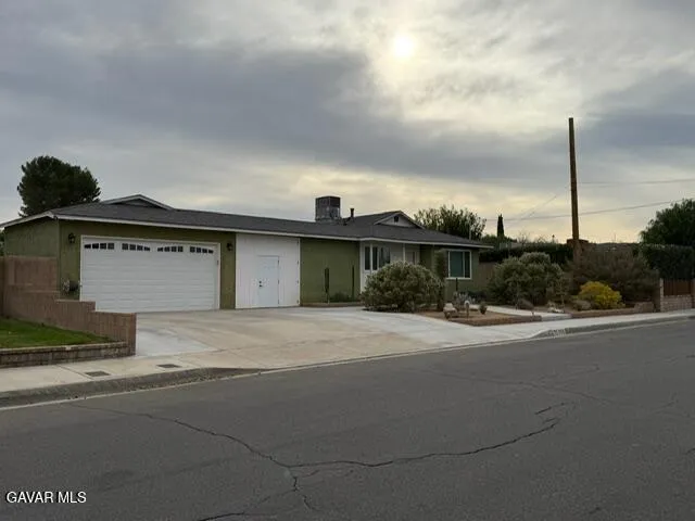 a front view of a house with a garden and parking
