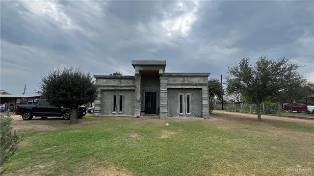 a view of a house with a big yard and large trees