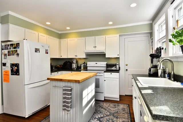 a kitchen with stainless steel appliances granite countertop a refrigerator and a stove top oven