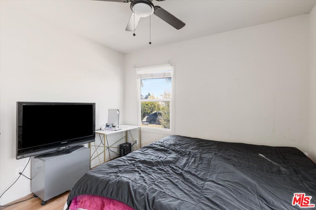 1206 West Magnolia Street Compton, CA 90220 - Photo 25 of 40 a bedroom with a bed and a flat screen tv