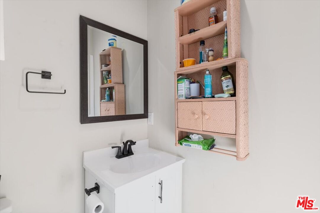 1206 West Magnolia Street Compton, CA 90220 - Photo 31 of 40 a bathroom with a sink and a mirror