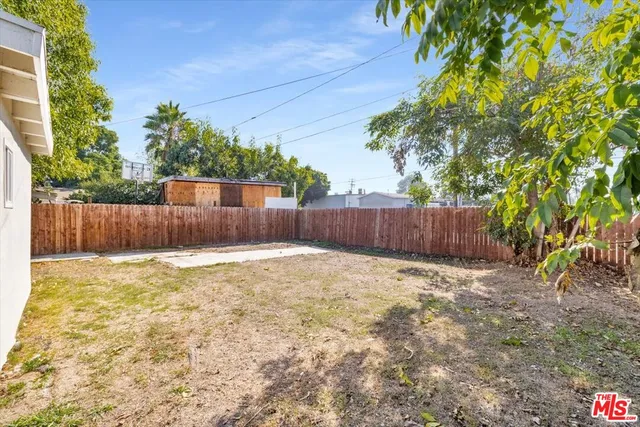 a view of a backyard with wooden fence
