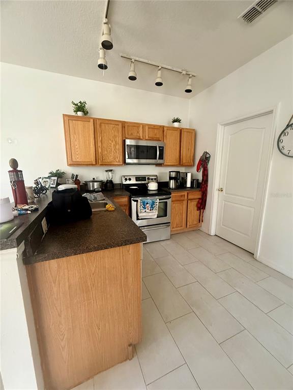 1008 Royal Ridge Drive Davenport, FL 33896 - Photo 8 of 19 a kitchen with kitchen island granite countertop a sink a stove top oven a counter space and cabinets