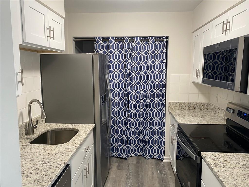 1166 Booth Road Southwest, Unit 610 Marietta, GA 30008 - Photo 2 of 20 a kitchen with a sink a stove and cabinets