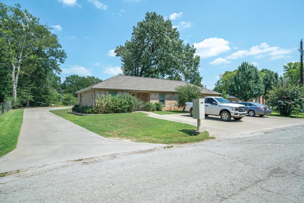202 Chestnut Drive Van, TX 75790 - Photo 3 of 12 Ranch-style home with a front lawn, brick siding, roof with shingles, and driveway
