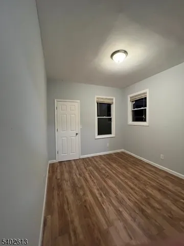 a view of a livingroom with wooden floor and window