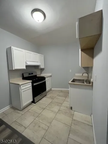 a kitchen with a sink a stove and cabinets