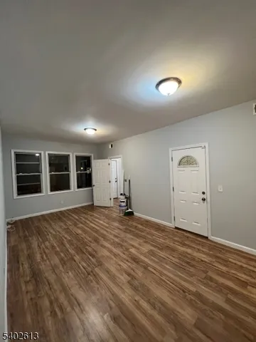 a view of a livingroom with wooden floor and a window