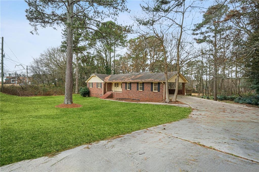 665 Arnold Road Lawrenceville, GA 30044 - Photo 13 of 38 a view of a house next to a big yard and large trees