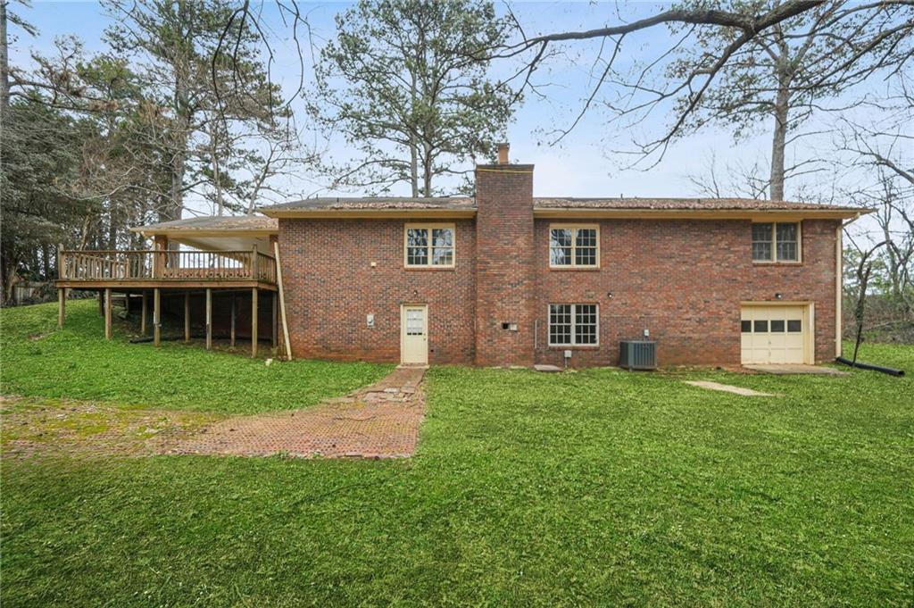 665 Arnold Road Lawrenceville, GA 30044 - Photo 24 of 38 a brick house next to a yard with a large tree