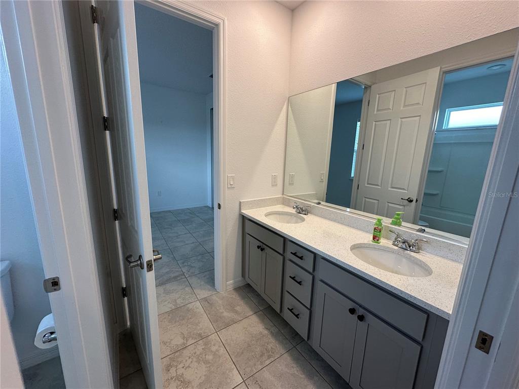 7526 Southwest 65th Place Road Ocala, FL 34474 - Photo 20 of 28 a bathroom with a double vanity sink and a mirror