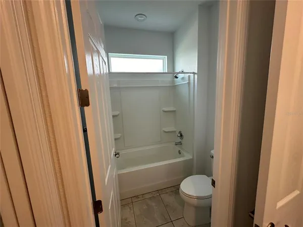 a view of an empty room with wooden floor and a floor to ceiling window