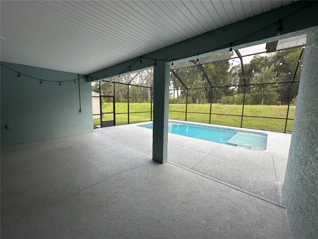 7526 Southwest 65th Place Road Ocala, FL 34474 - Photo 25 of 28 a view of an empty room with wooden floor and a floor to ceiling window