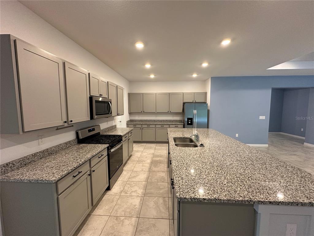7526 Southwest 65th Place Road Ocala, FL 34474 - Photo 9 of 28 a kitchen with stainless steel appliances granite countertop a sink stove and refrigerator