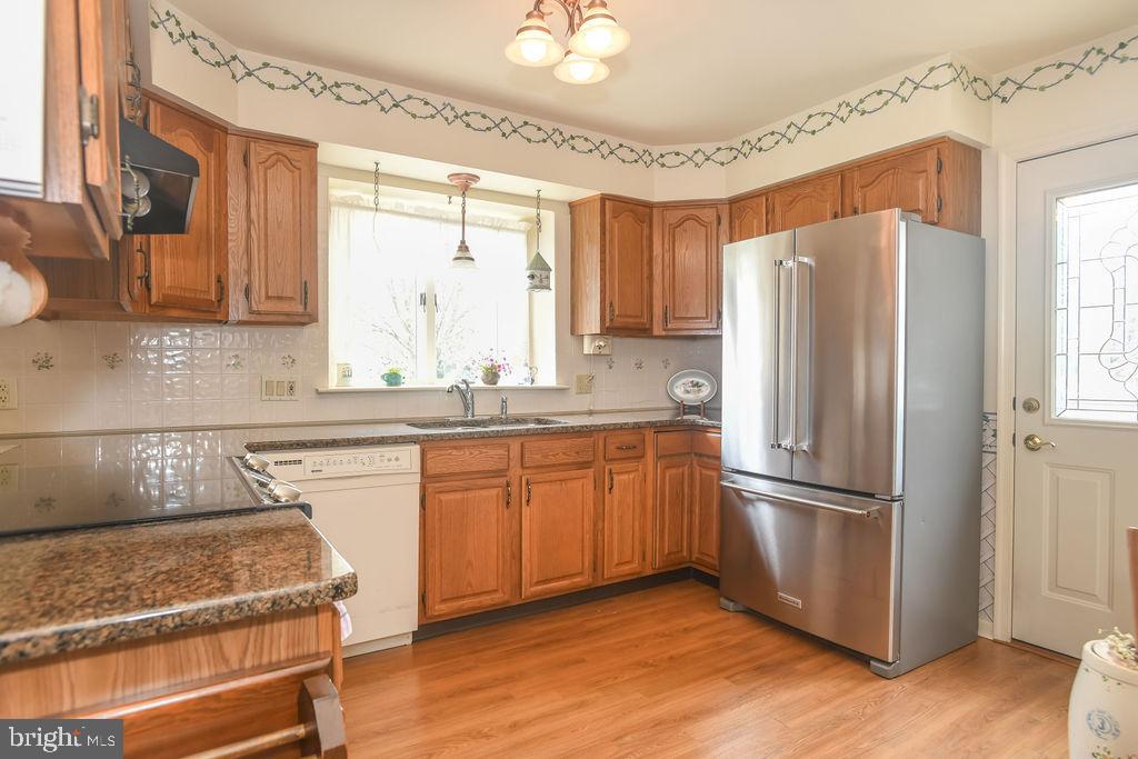 2 Battle Drive Newark, DE 19702 - Photo 12 of 35 a kitchen with granite countertop stainless steel appliances a refrigerator cabinets and wooden floor