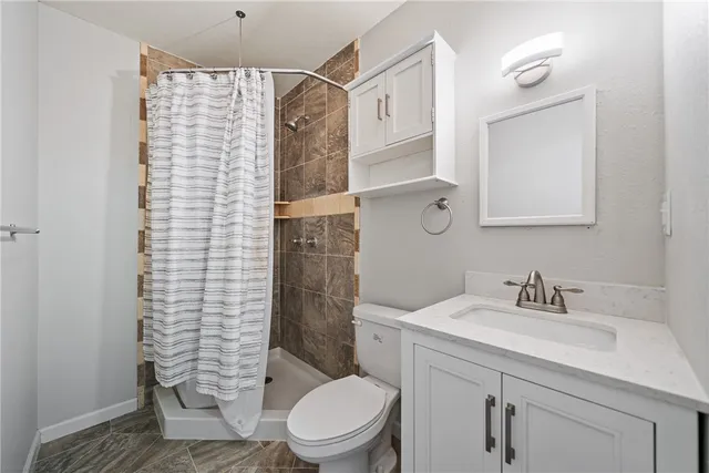 a bathroom with a granite countertop toilet and a sink