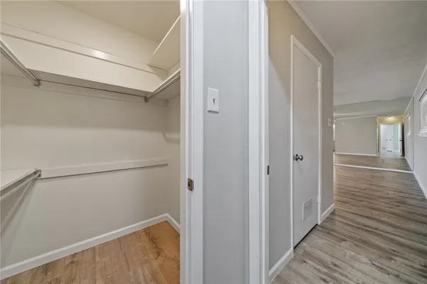 a view of walk in closet with empty racks