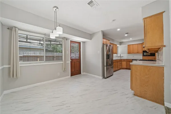 a view of kitchen with refrigerator and window
