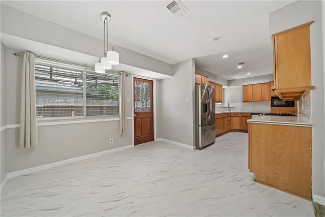 a view of kitchen with refrigerator and window