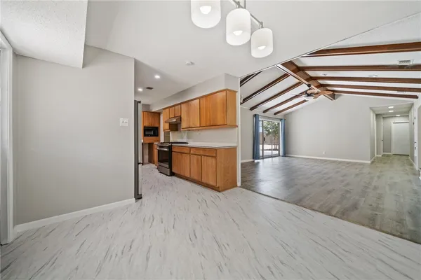 a kitchen with granite countertop wooden cabinets stainless steel appliances and a sink