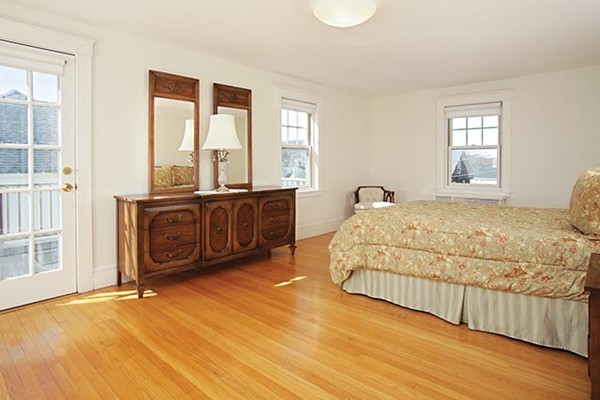 42 Lovell Road Watertown, MA 02472 - Photo 4 of 6 a spacious bedroom with a bed a table and three windows