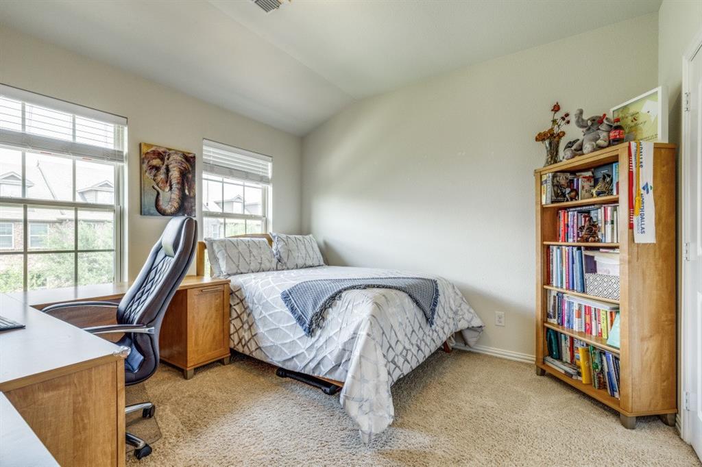 3932 Asbury Lane Addison, TX 75001 - Photo 15 of 18 a bed room with a bed and a book shelf