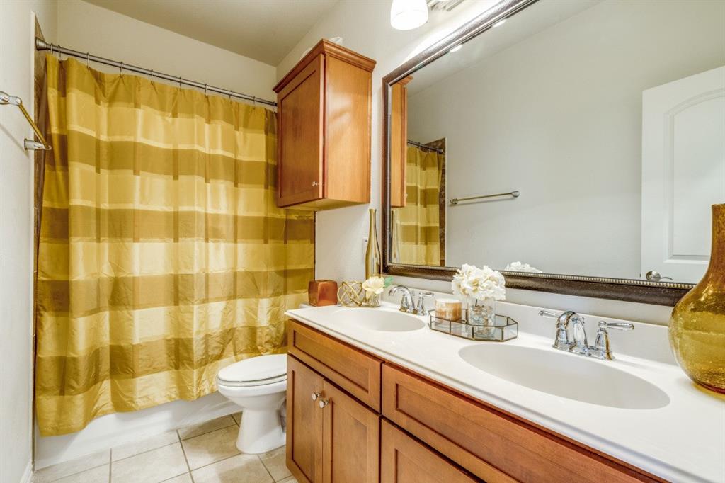 3932 Asbury Lane Addison, TX 75001 - Photo 16 of 18 a bathroom with a double vanity sink toilet and shower