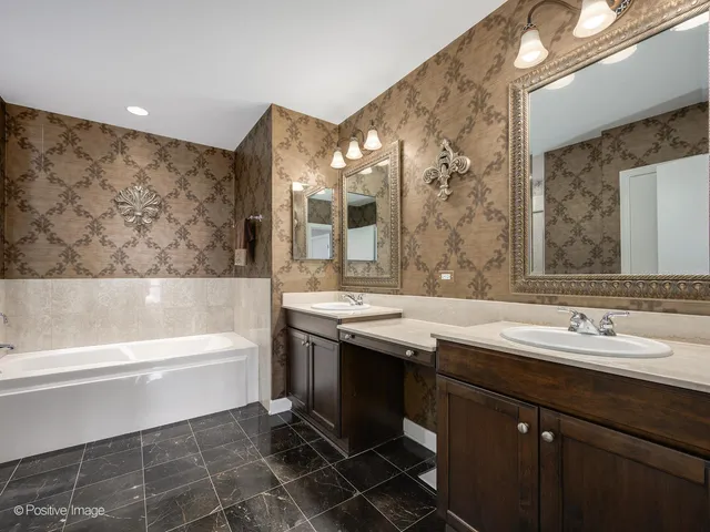 a bathroom with a granite countertop sink mirror and bathtub