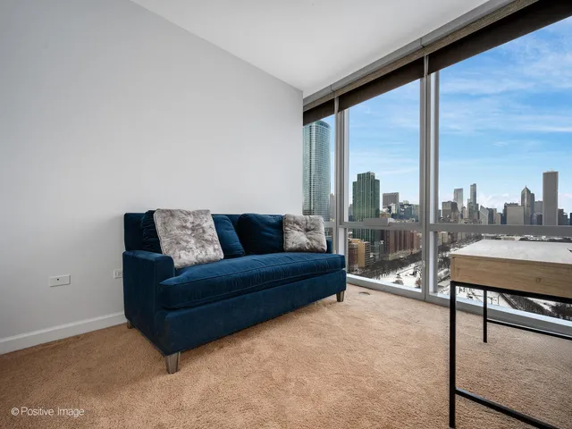 a living room with furniture a city view and a large window