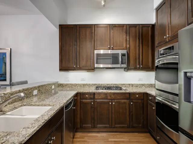 a kitchen with stainless steel appliances granite countertop a stove microwave and refrigerator