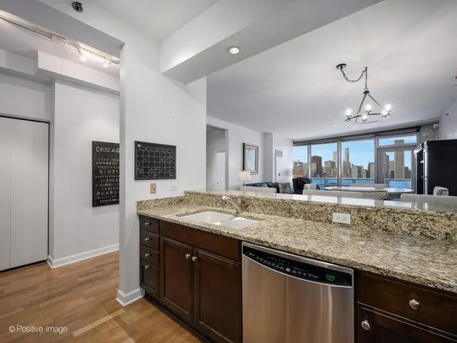 a kitchen with granite countertop a sink and a wooden floor