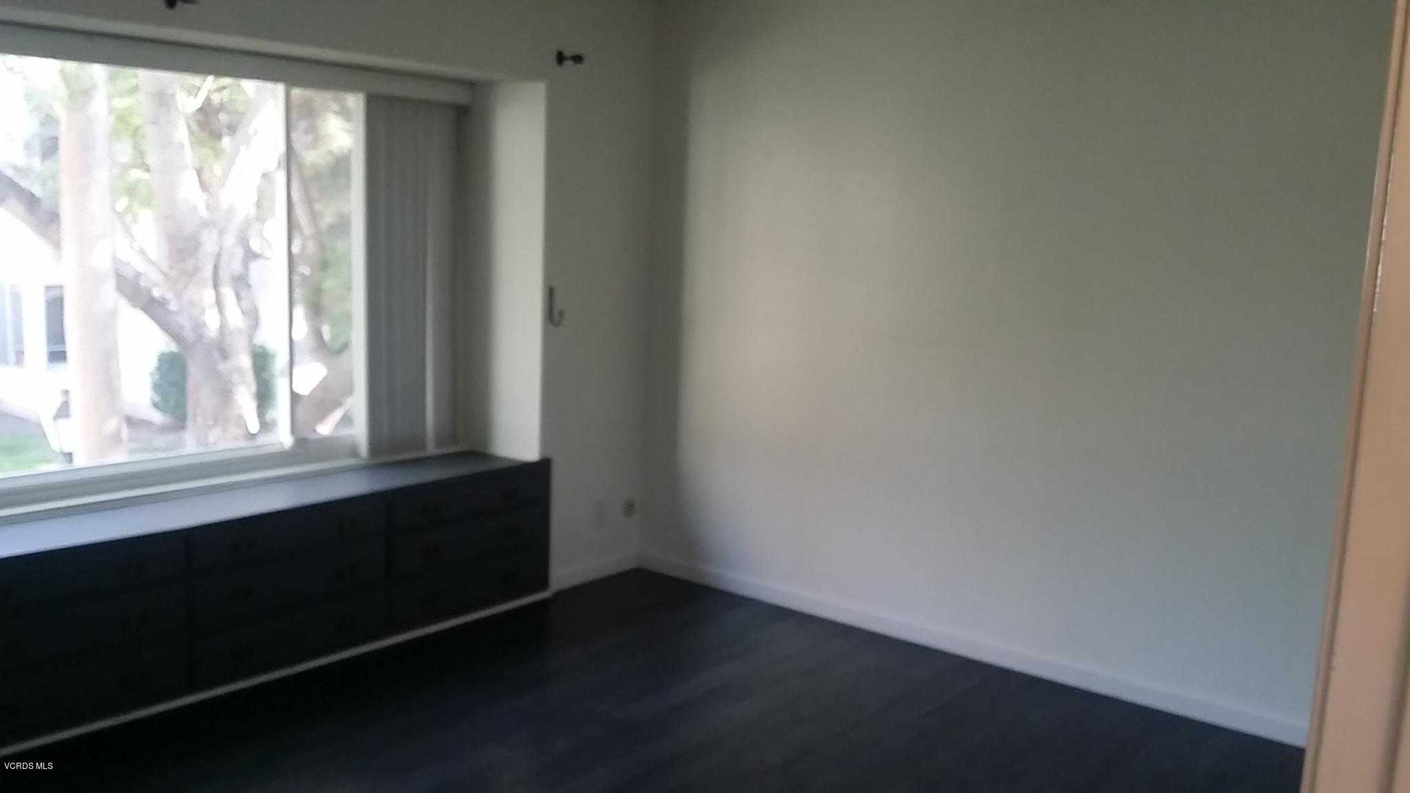15076 Varsity Street, Unit C Moorpark, CA 93021 - Photo 11 of 18 a view of an empty room with wooden floor and a window