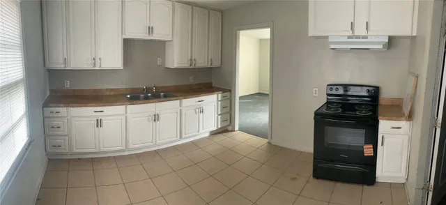 a kitchen with white cabinets and appliances