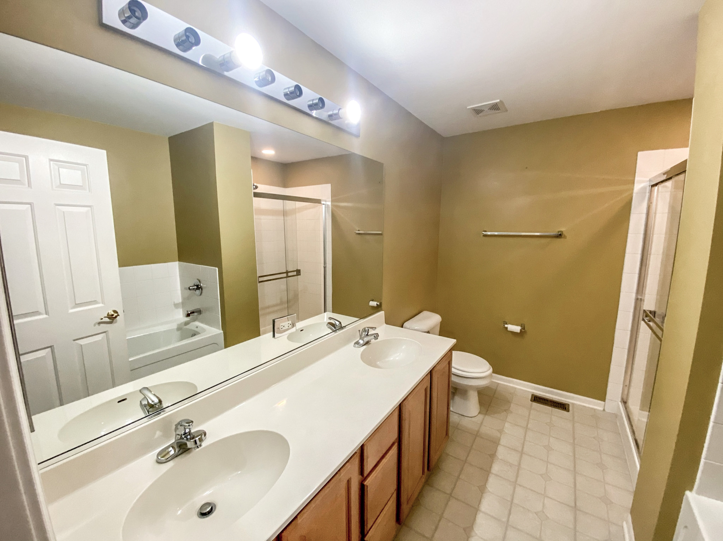 2249 Hudson Circle Aurora, IL 60502 - Photo 17 of 30 a spacious bathroom with a double vanity sink a mirror and a bathtub