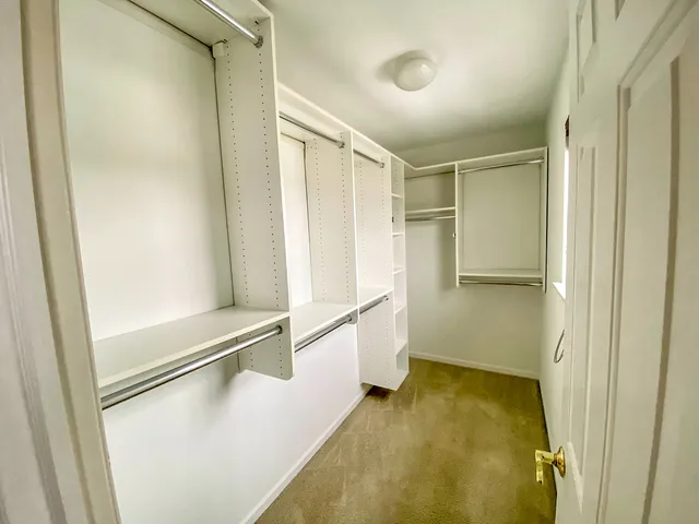 a view of walk in closet with empty racks